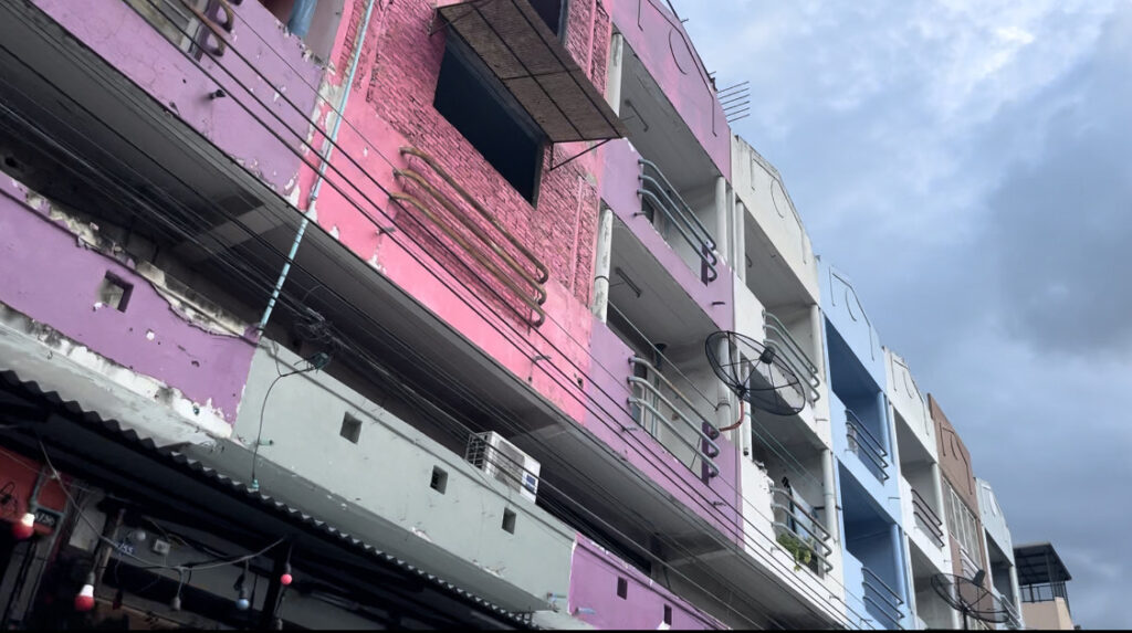 a colourful pink condo building where locals live in Thailand