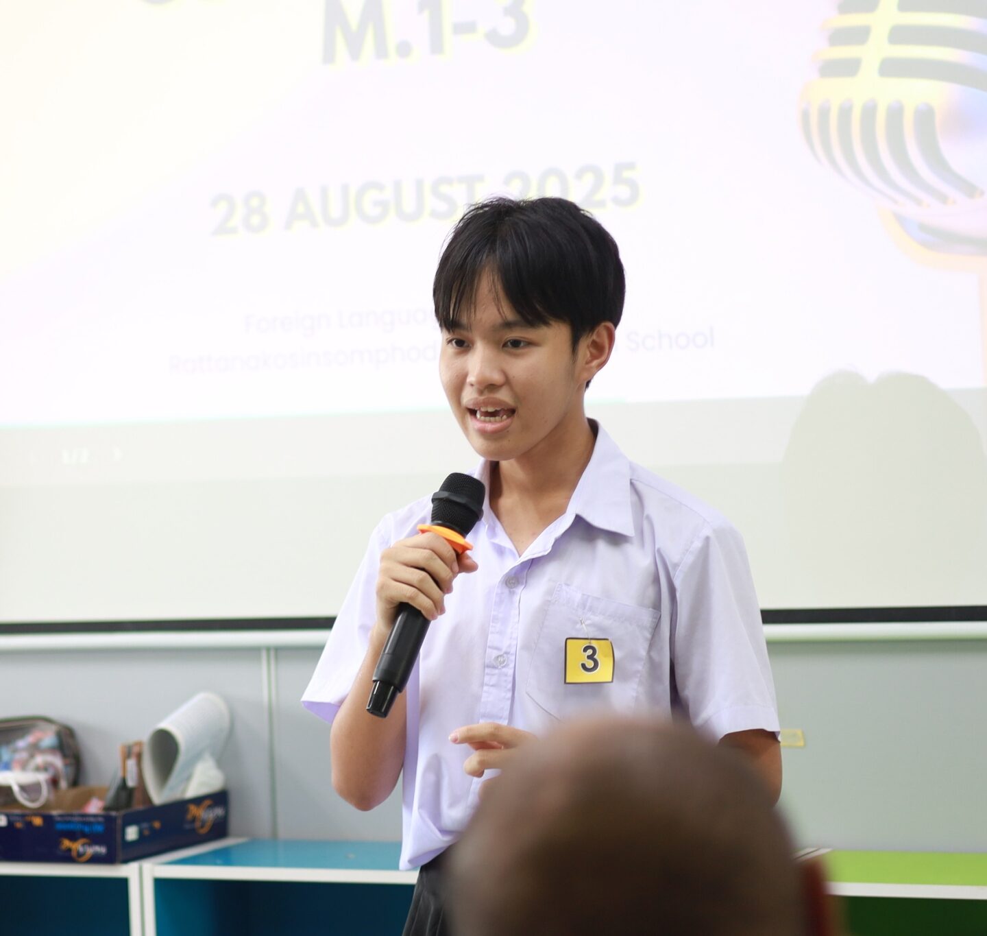A student speaks to their teachers during an English Competition at a school in Thailand
