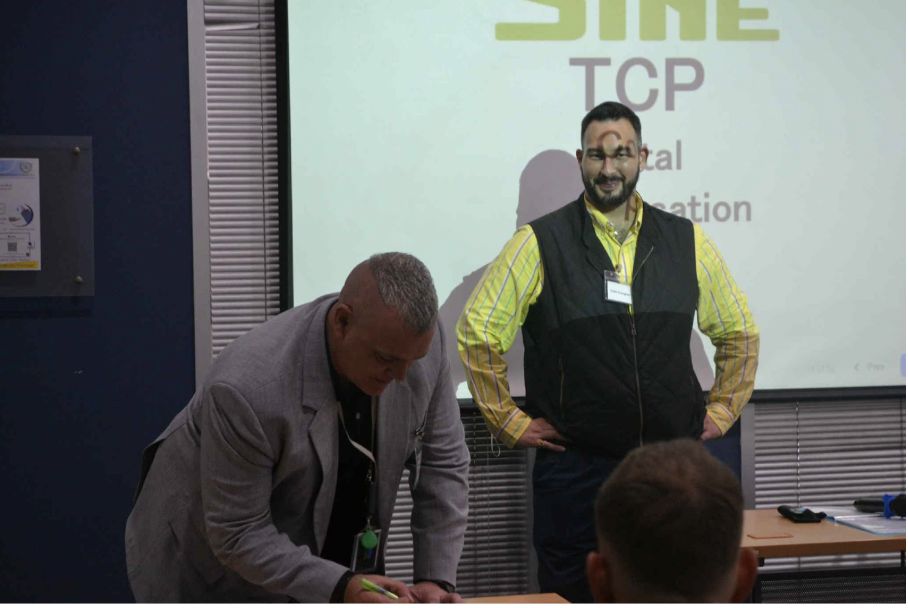 teacher stands with another at the front of teacher training room