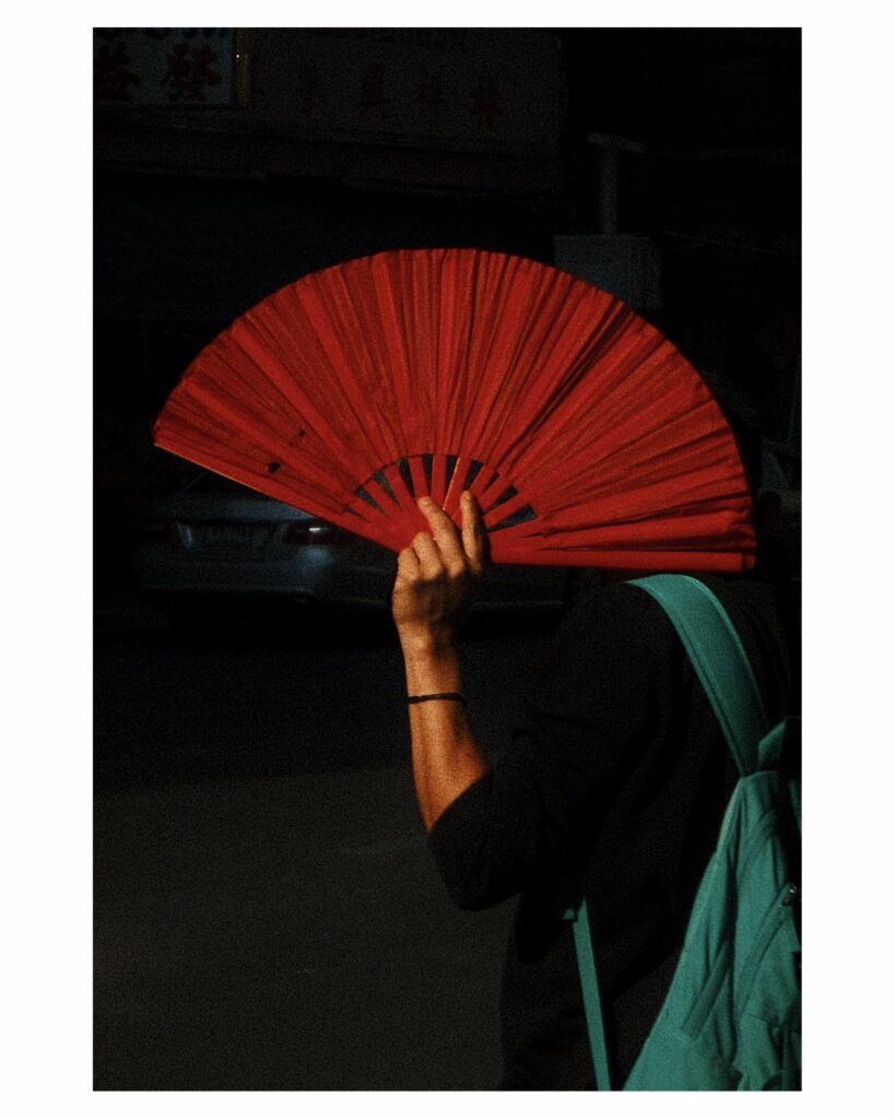 a bright red fan held by a tour guide in Bangkok's Old Town