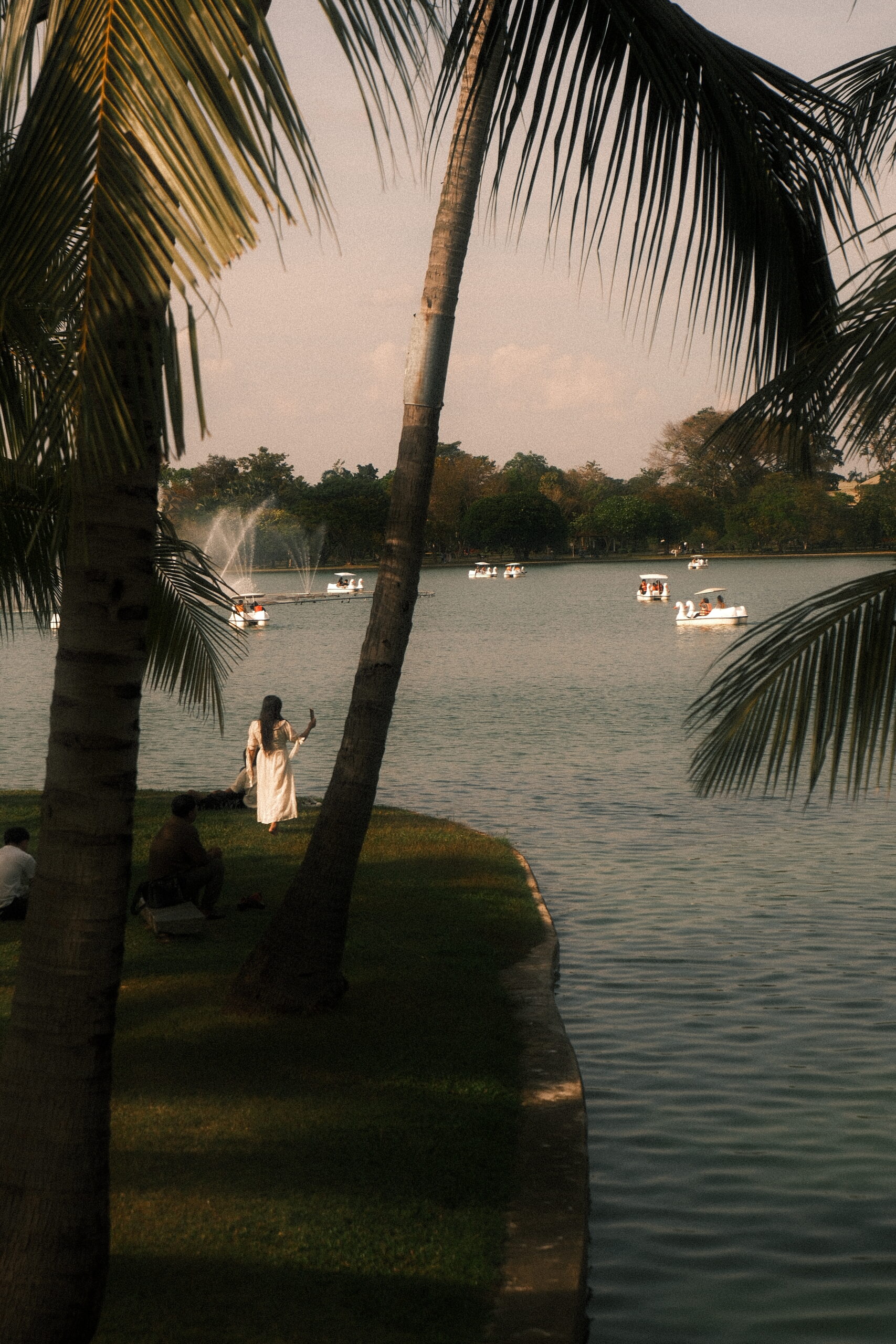 A woman stands by the lake in Suan Luang Rama IX Park