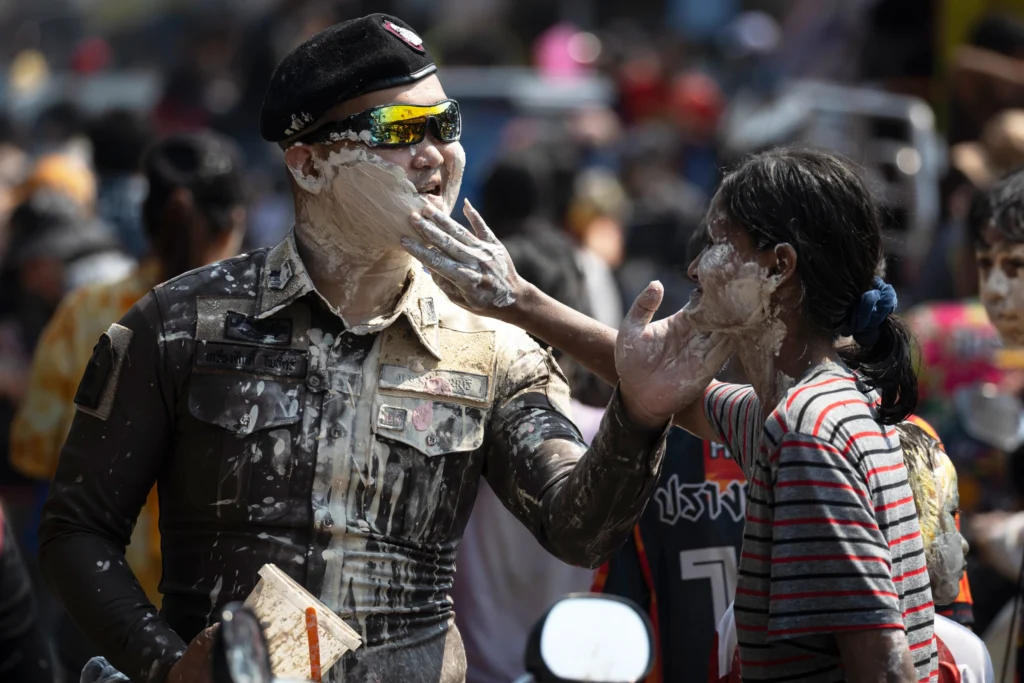 a police officer and a civilian share chalk at songkran in Bangok