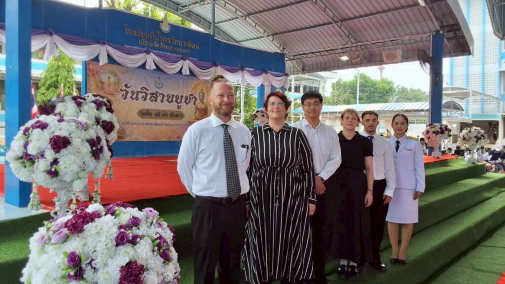 Teacher with SINE Education in Thailand in front of the school stage
