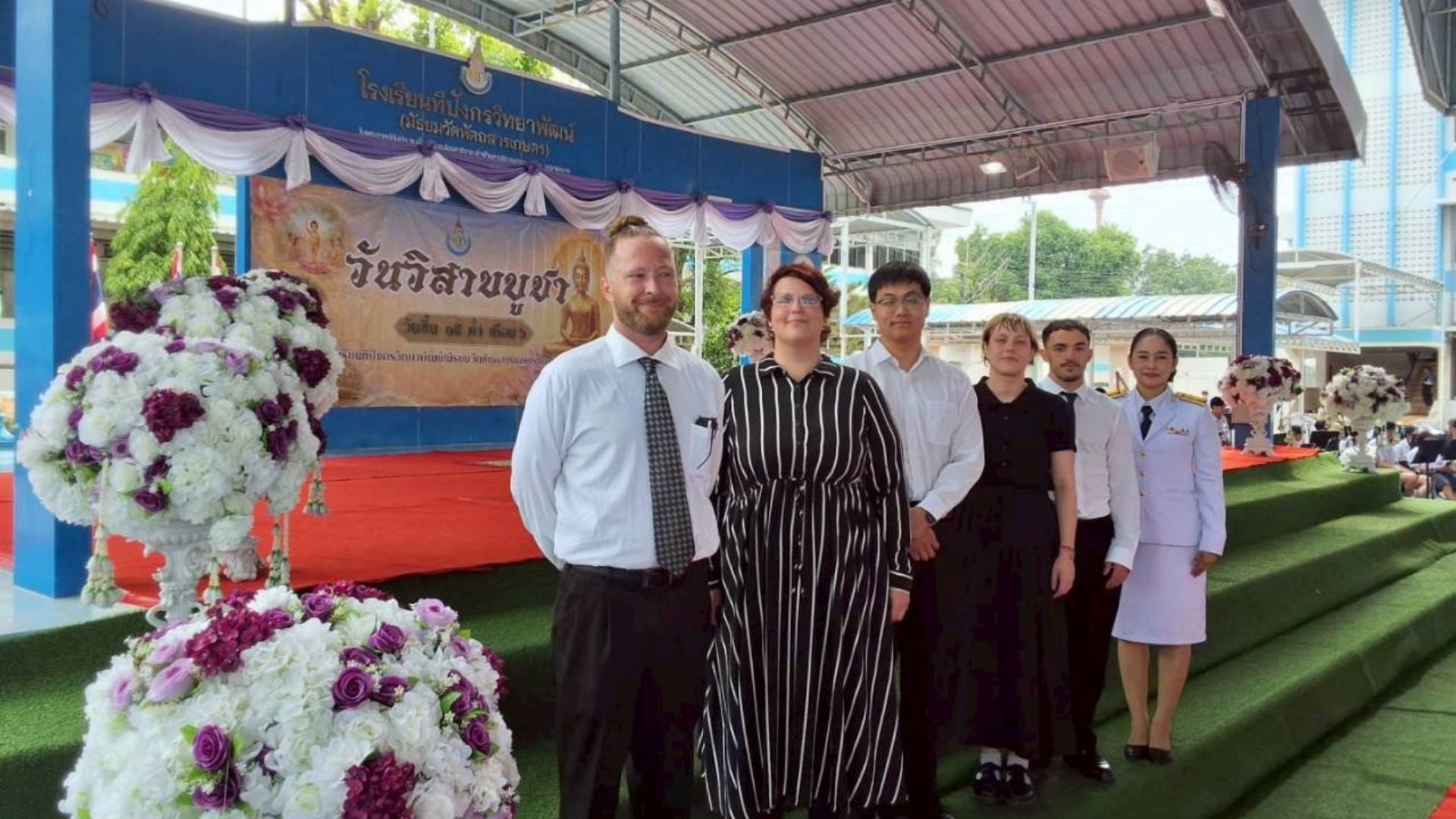 Teacher with SINE Education in Thailand in front of the school stage