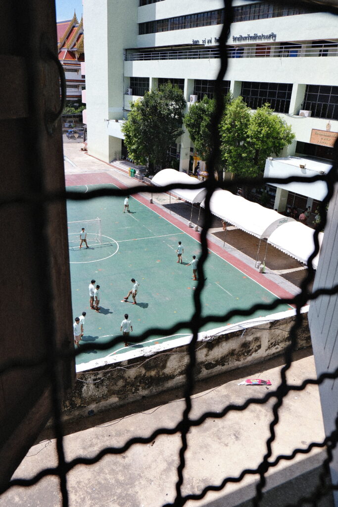 Students playing football at school in Bangkok